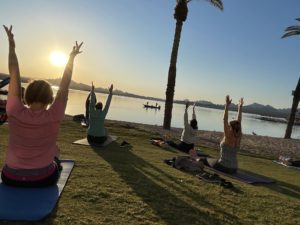 Women doing yoga on the lakefront at the Nautical Beachfront Resort